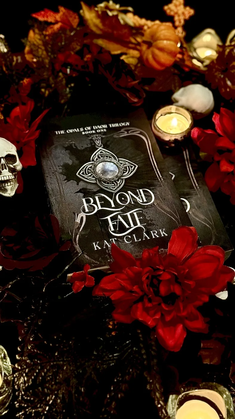 Copy of Beyond Fate surrounded by red flowers, candles, a pumpkin and a skull